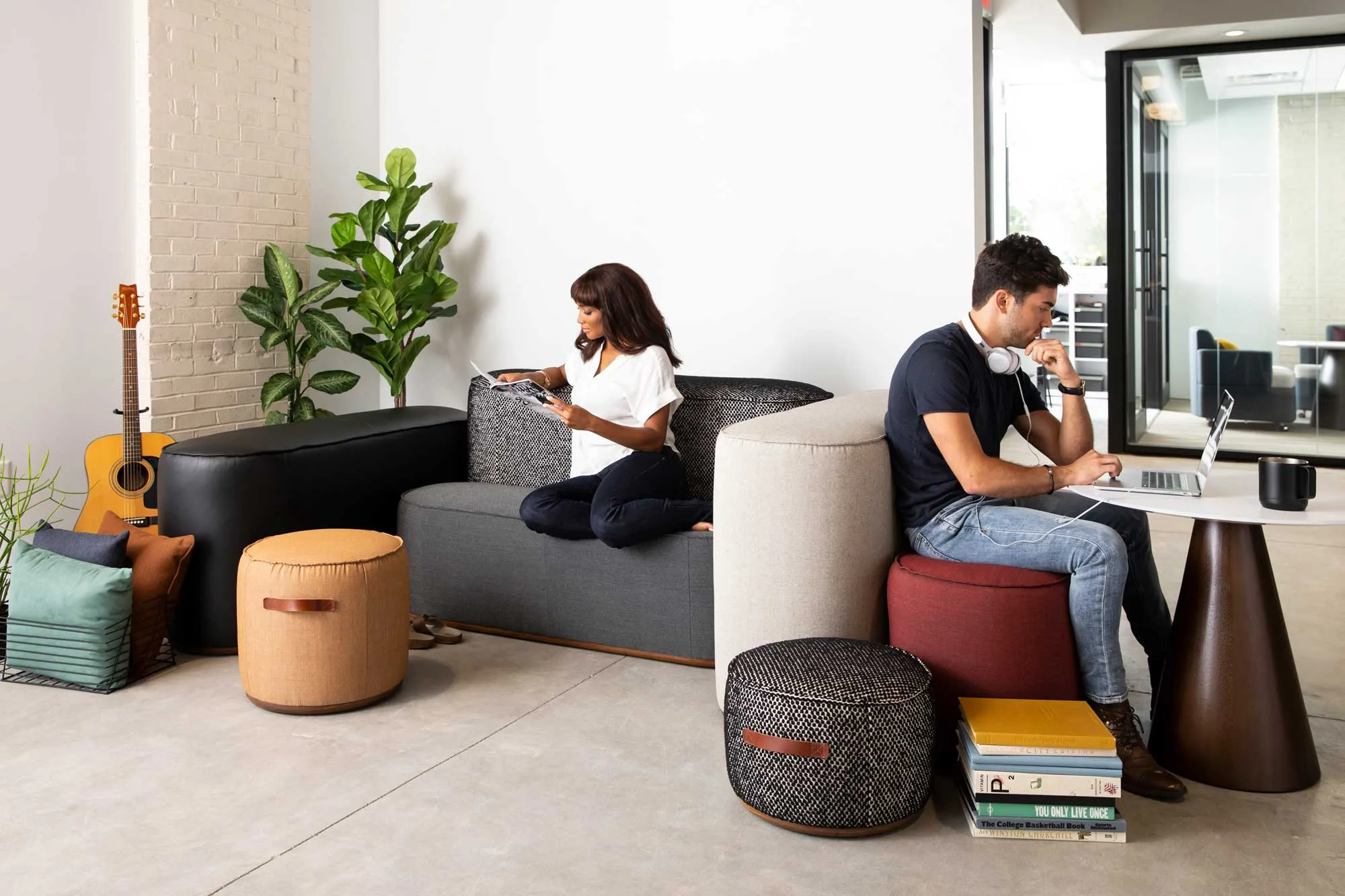 A lounge with soft seating where two people work independently